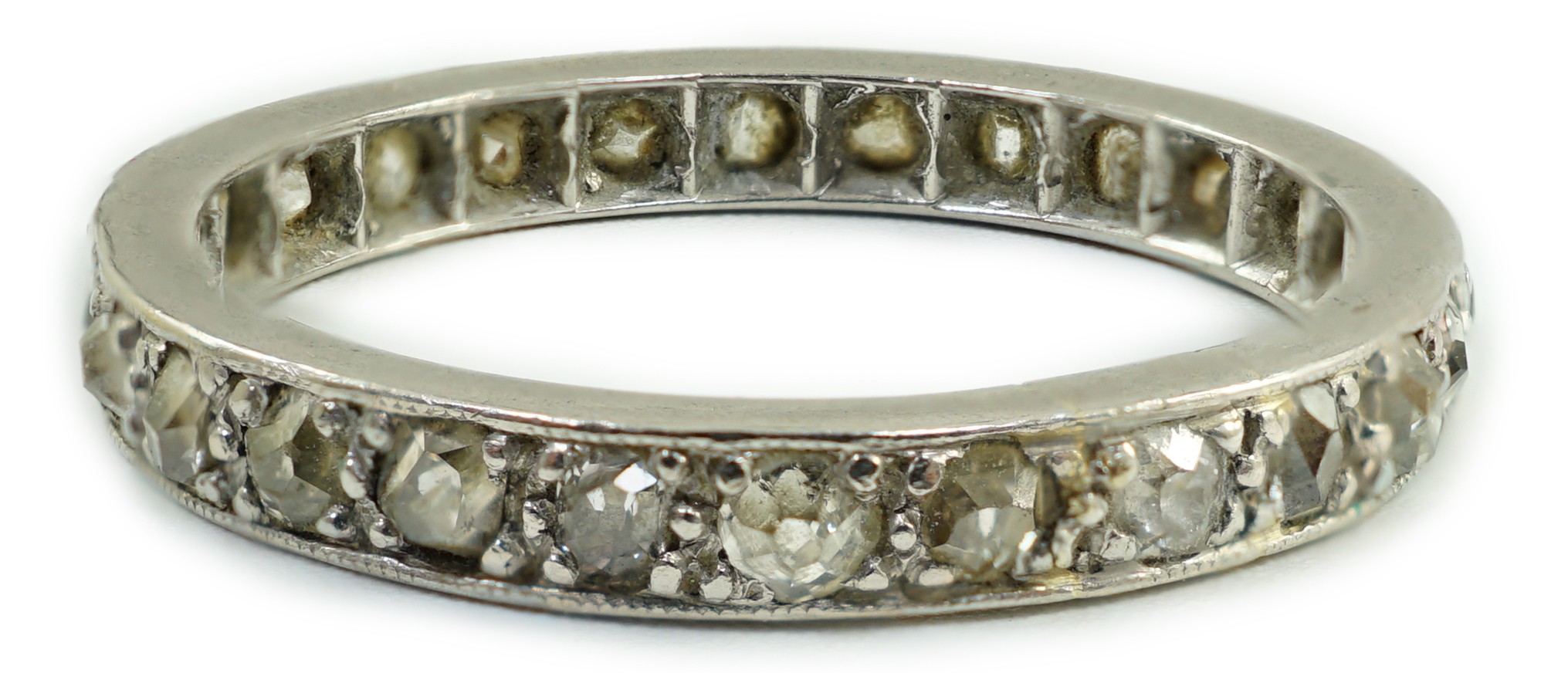 A white metal and diamond chip set full eternity ring, size L, gross weight 2.7 grams.